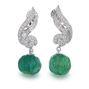 Pair of elegant white gold drop earrings featuring carved green emeralds and diamond-encrusted swirling designs.