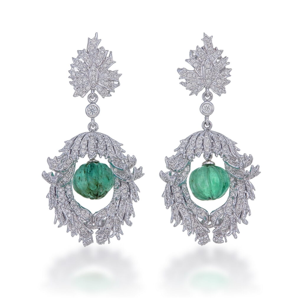 Pair of white gold Timeless Emerald Bloom Earrings with carved green emerald drops and diamond-encrusted scroll motifs.
